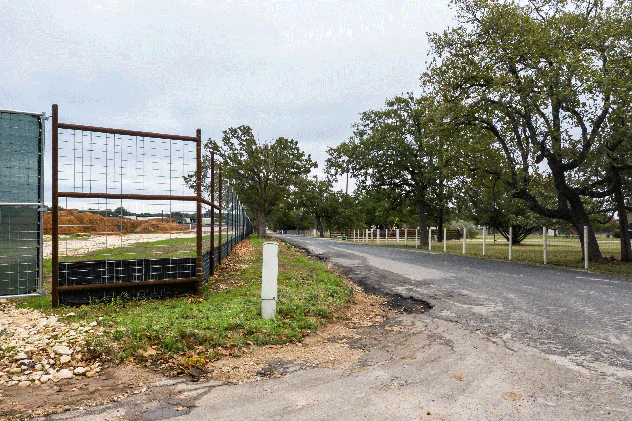 Tall black fence next to a road