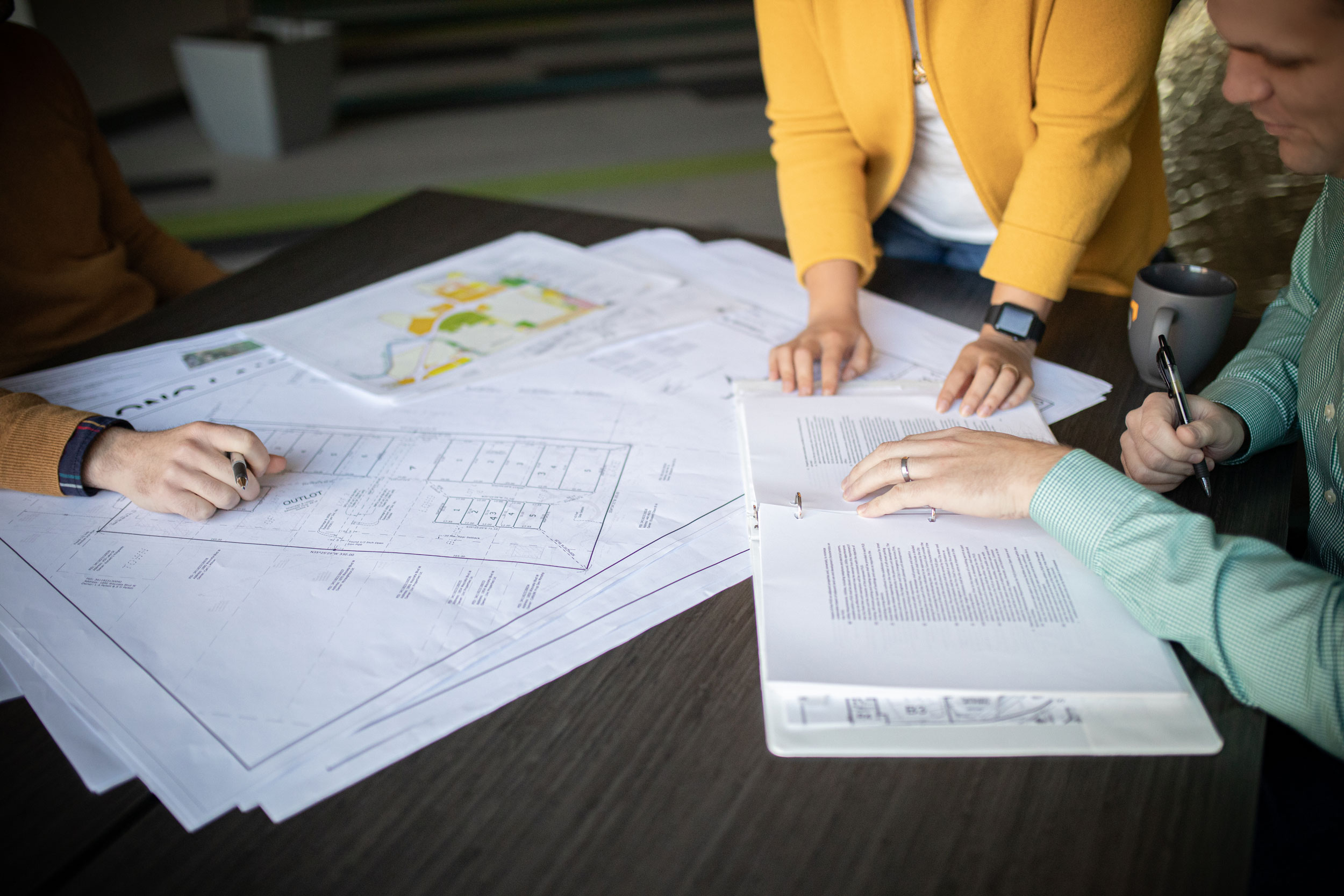 People working on community planning documents on a desk