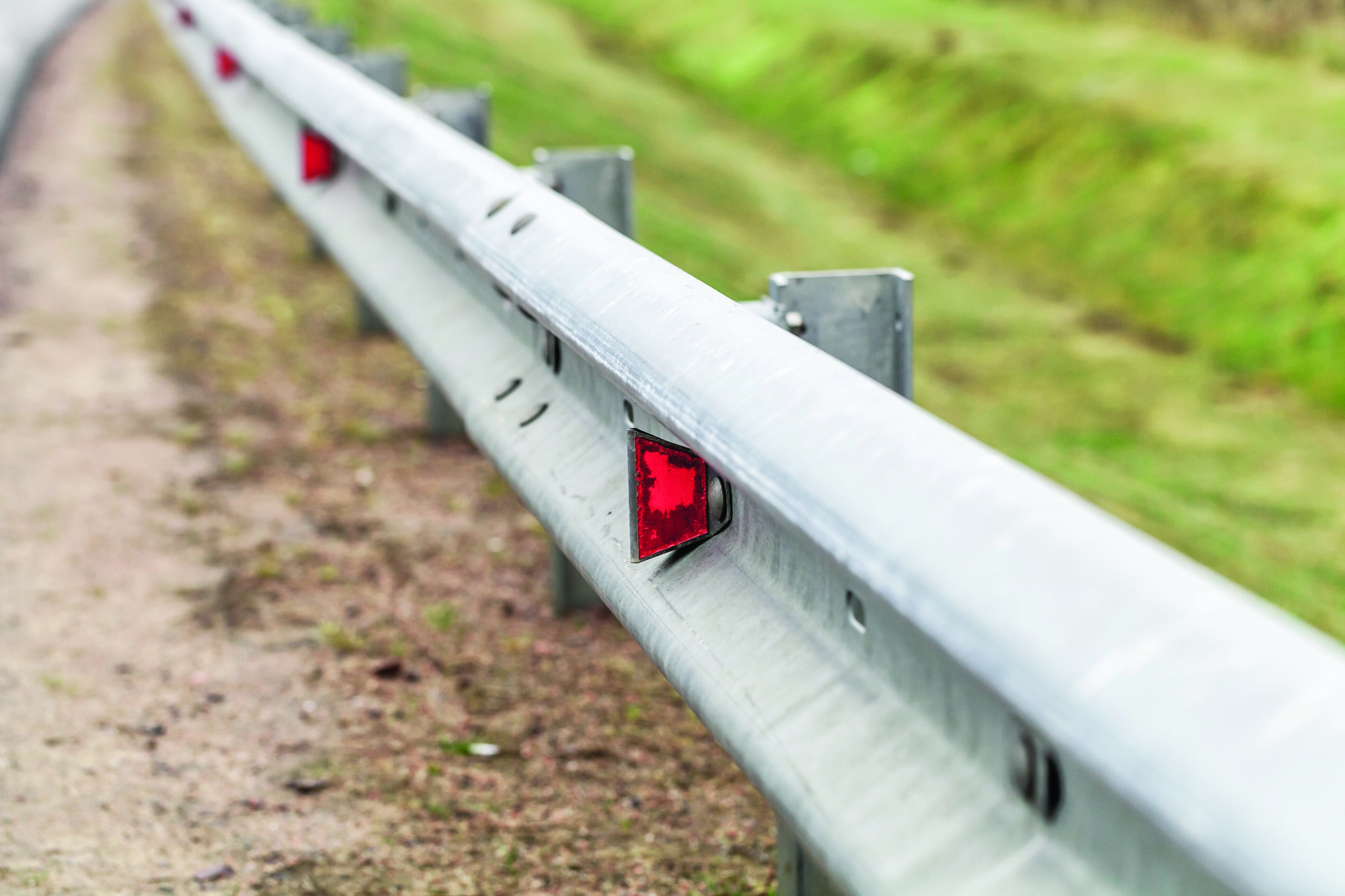 Metal guardrail mounted on a highway roadside, safety equipment