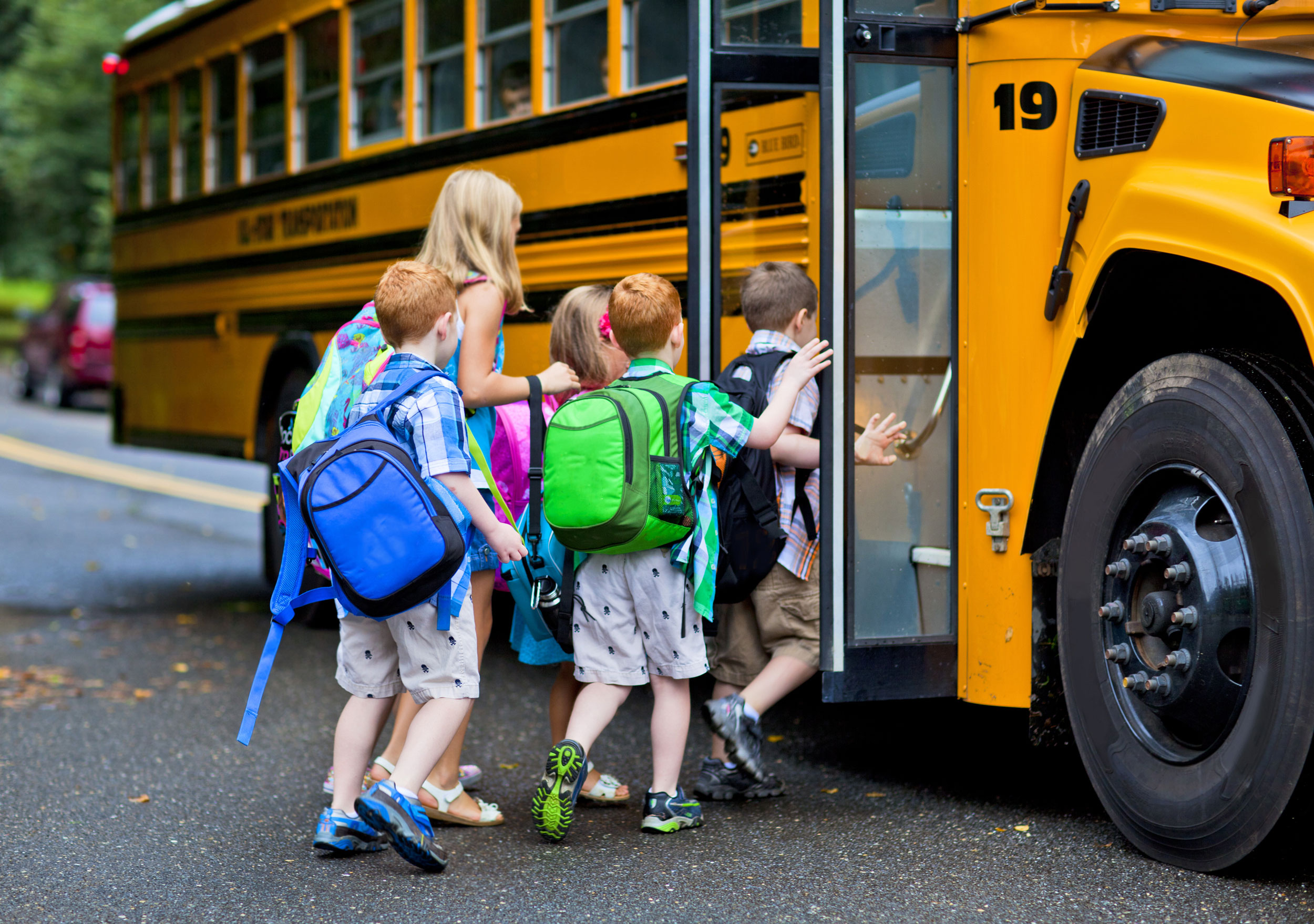 Photo of children getting on a school bus.