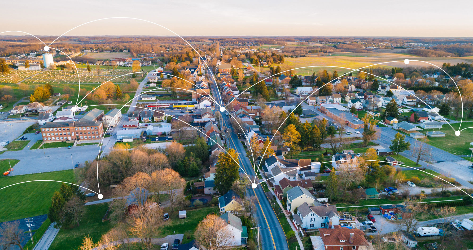 Aerial of small city with lines connecting various city services like water towers and intersections