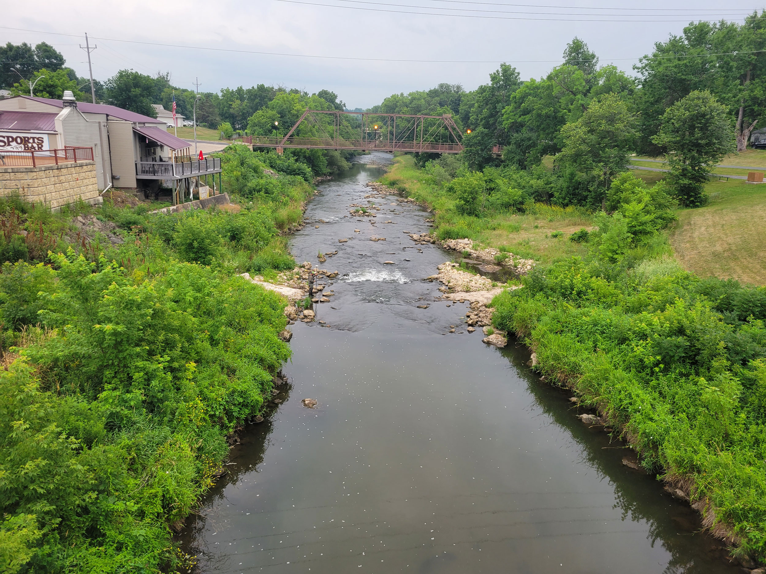 Zumbro river with a bridge over it and a restaurant on the left side.