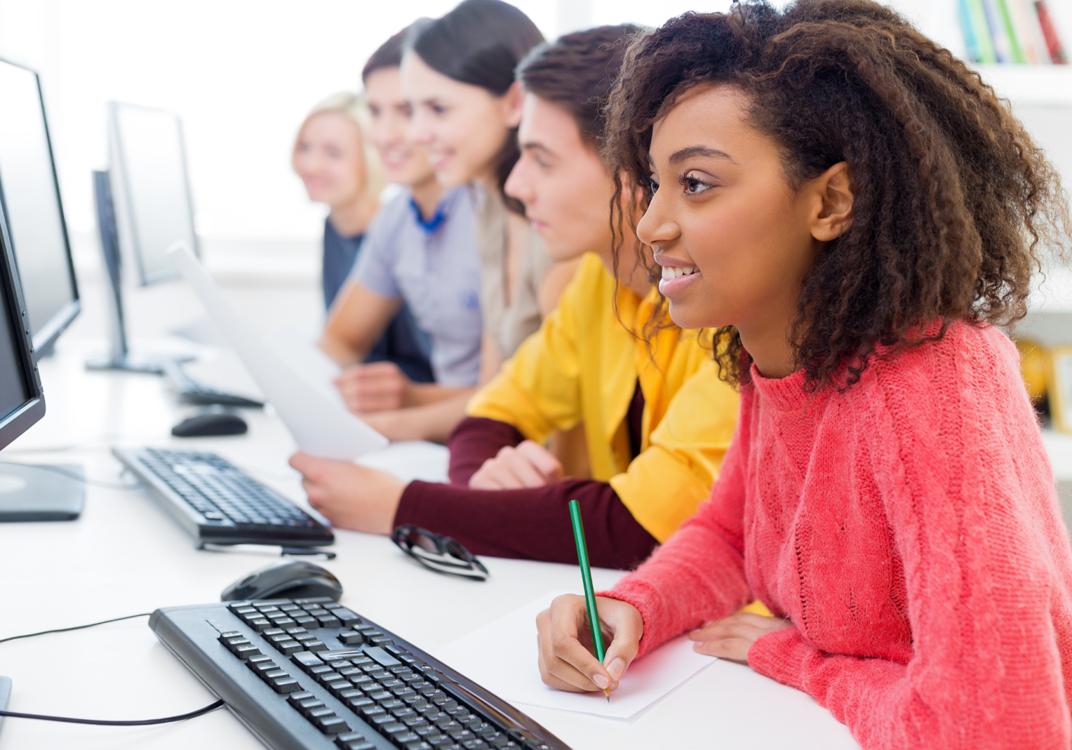 People sitting at a table looking at their own computer
