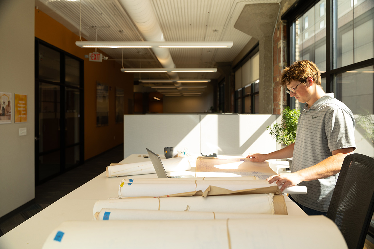 Person working on blueprints on a desk in an office
