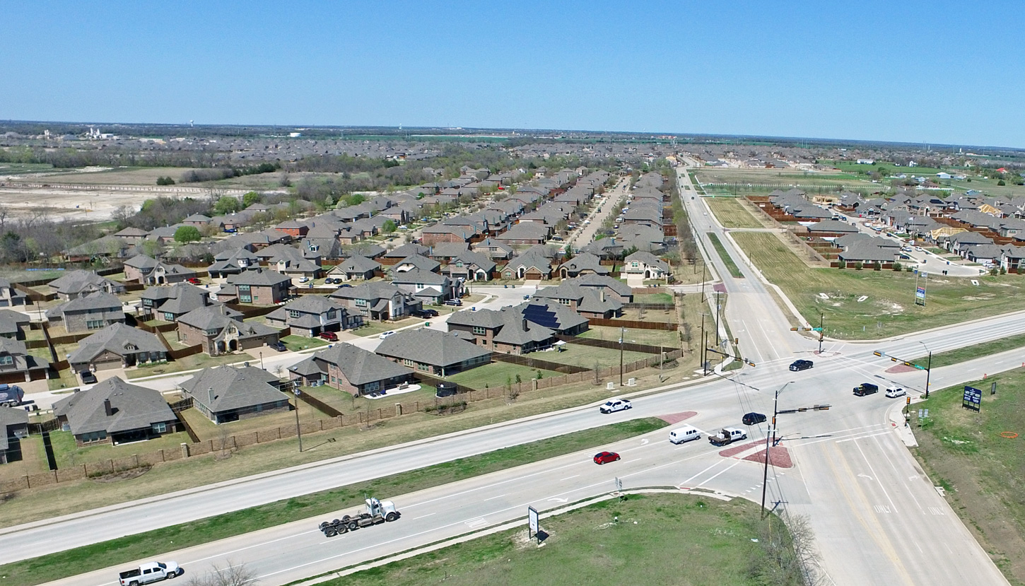 Aerial view of an intersection near a suburban development.
