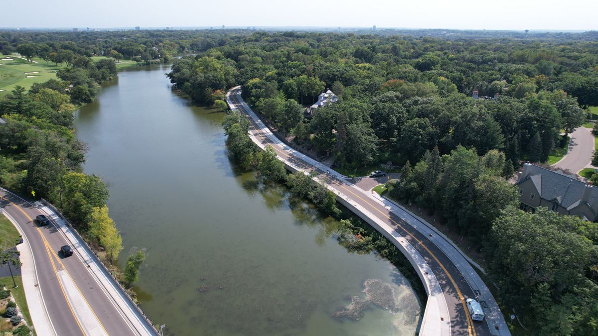 Road near a body of water with a bridge and roundabout