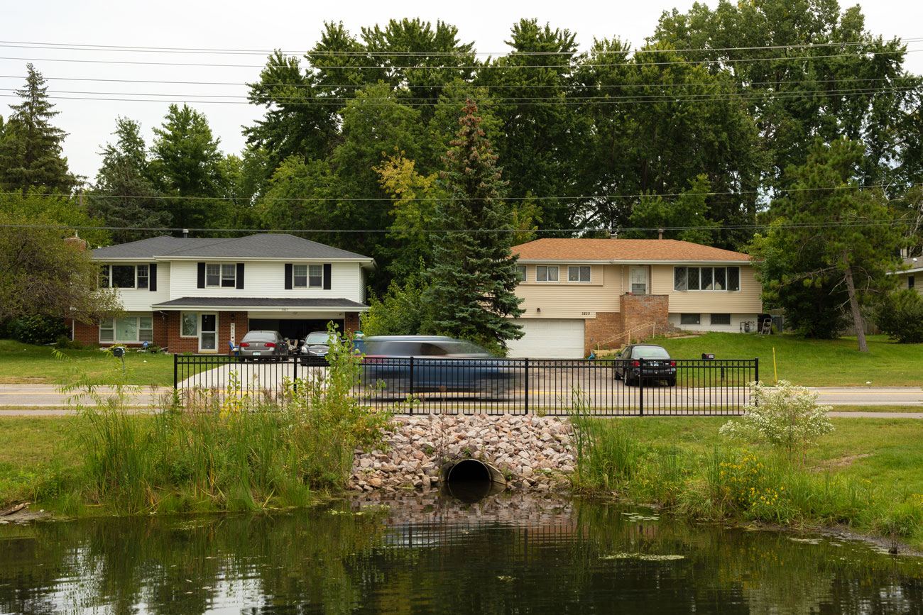 Storm water culvert with storm water retention pond near a street