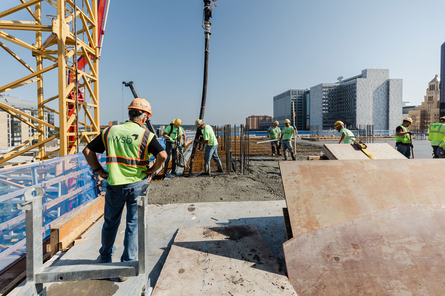 Engineers on a commercial building rooftop pouring concrete.