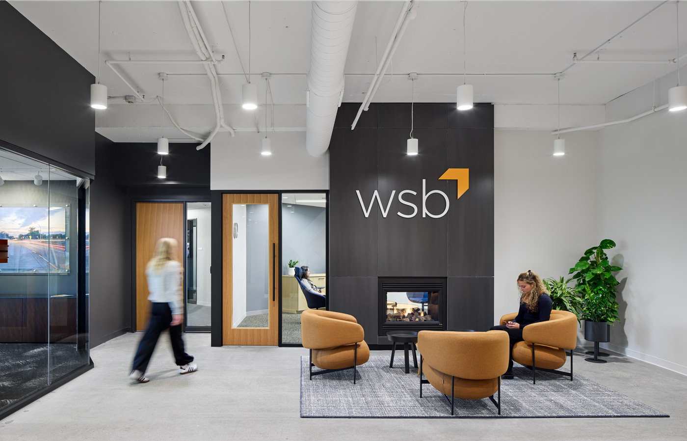WSB office lobby with fireplace and chairs with two people.
