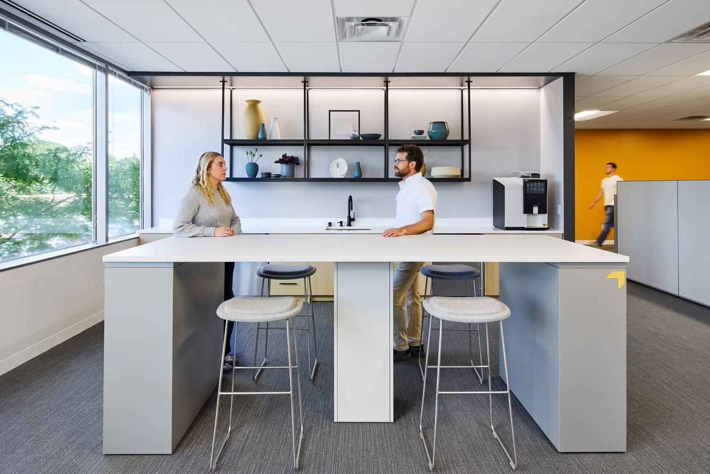 Two staff members standing in the WSB office near a table.