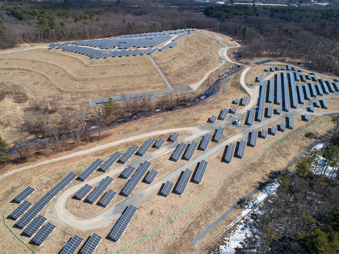 Aerial perspective of the solar photovoltaic system at the Tewksbury landfill site, highlighting above‑grade panel installation and site circulation paths.