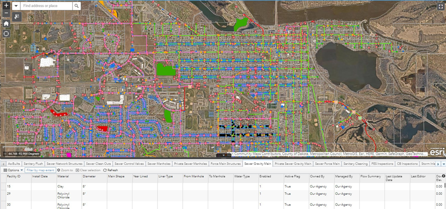 GIS web map showing a citywide sanitary sewer system with color‑coded sewer mains, manholes, and related infrastructure over an aerial basemap, with attribute tables displayed below the map.