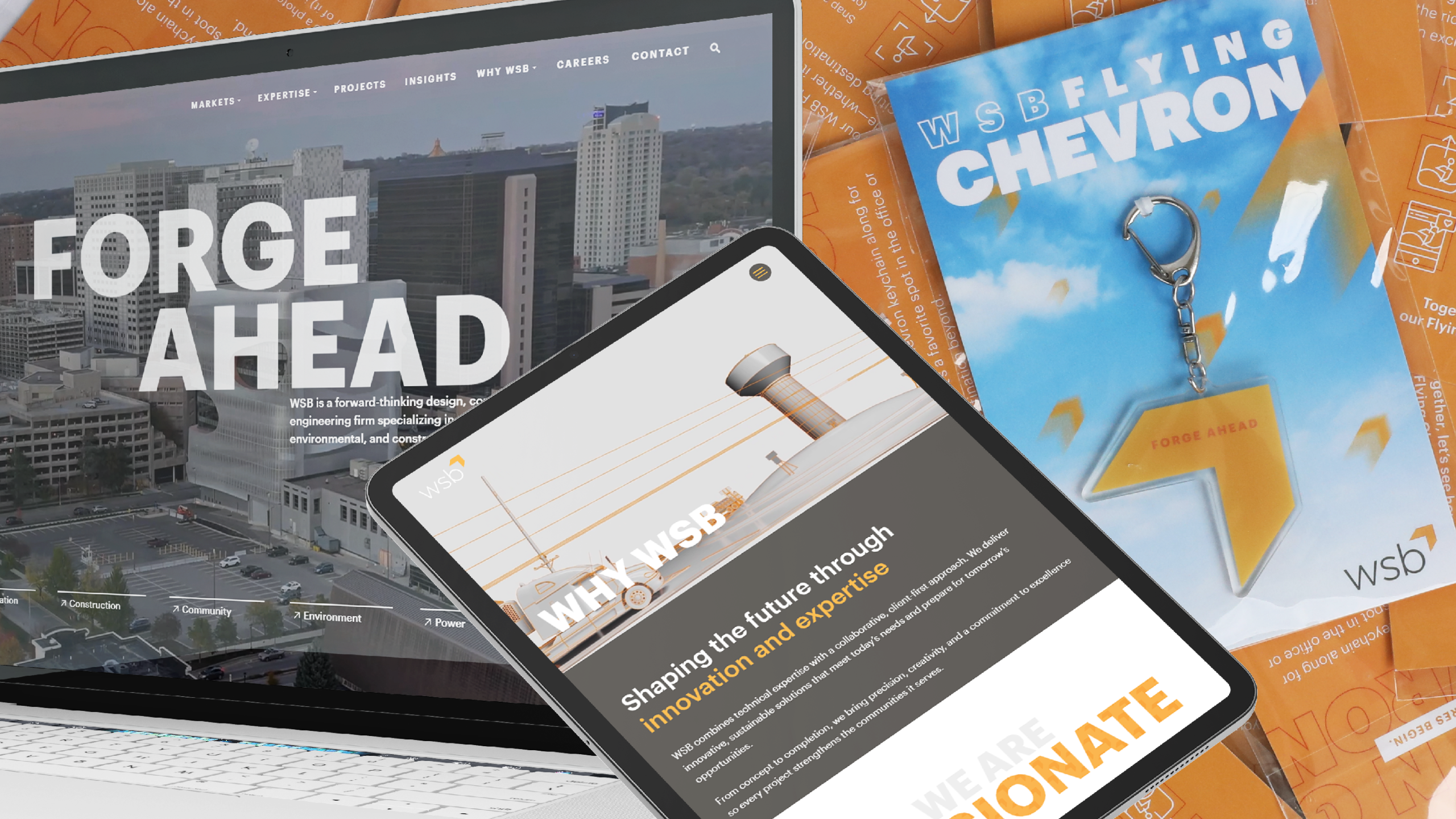 Promotional WSB brand collage featuring a laptop displaying the WSB website homepage with the headline “FORGE AHEAD,” a tablet showing WSB service and innovation content, and a packaged “WSB Flying Chevron” promotional item with a carabiner clip. All items are arranged on an orange WSB-branded background with company graphics and messaging.