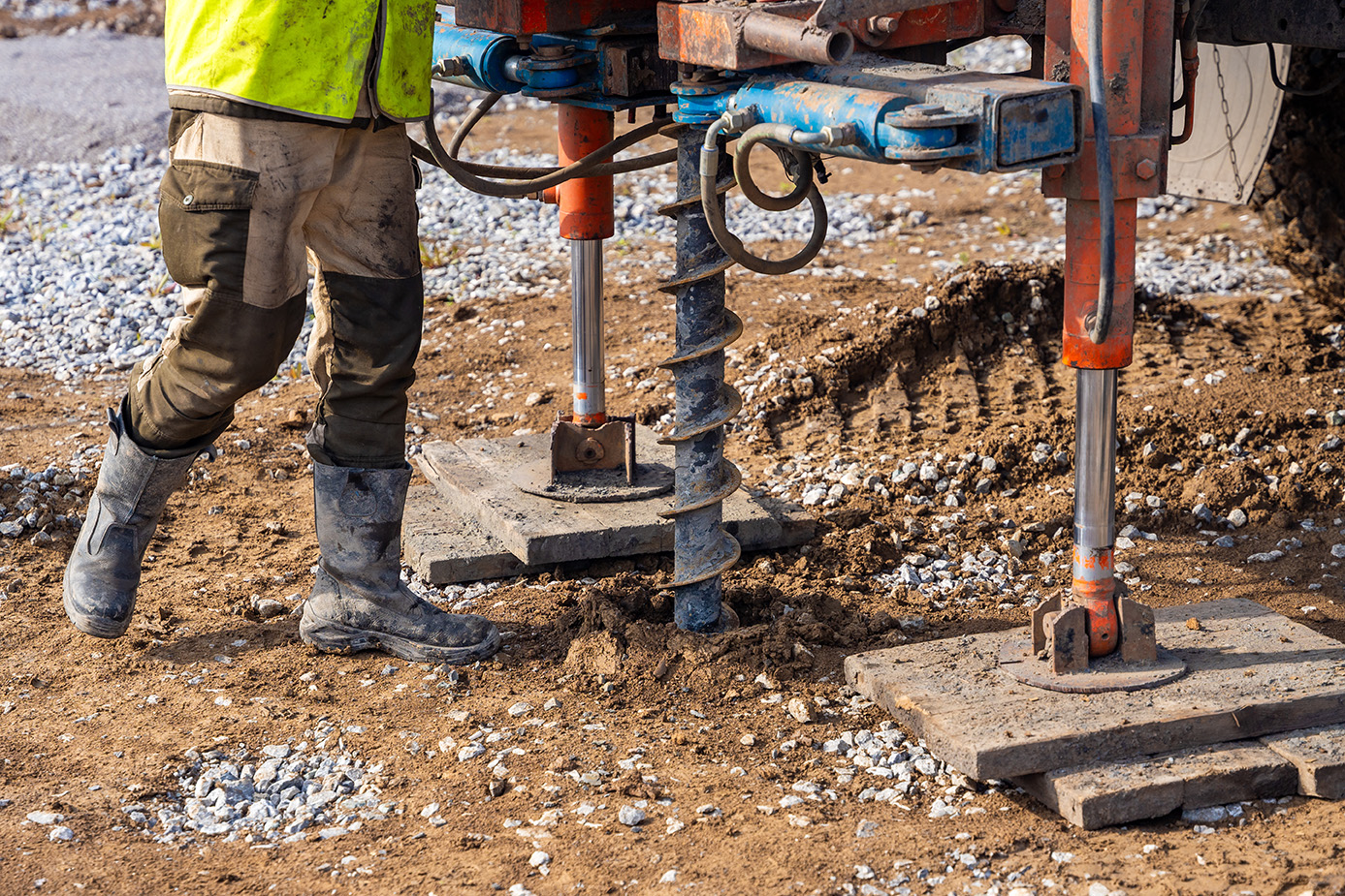Field crew conducting subsurface investigation with auger drilling equipment to evaluate soil conditions and collect samples for geotechnical analysis.